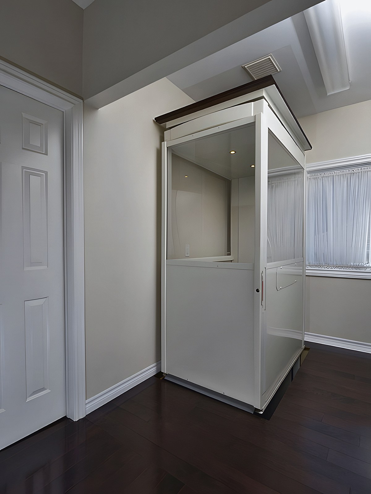 Home lift with a white cabin beside the doorway