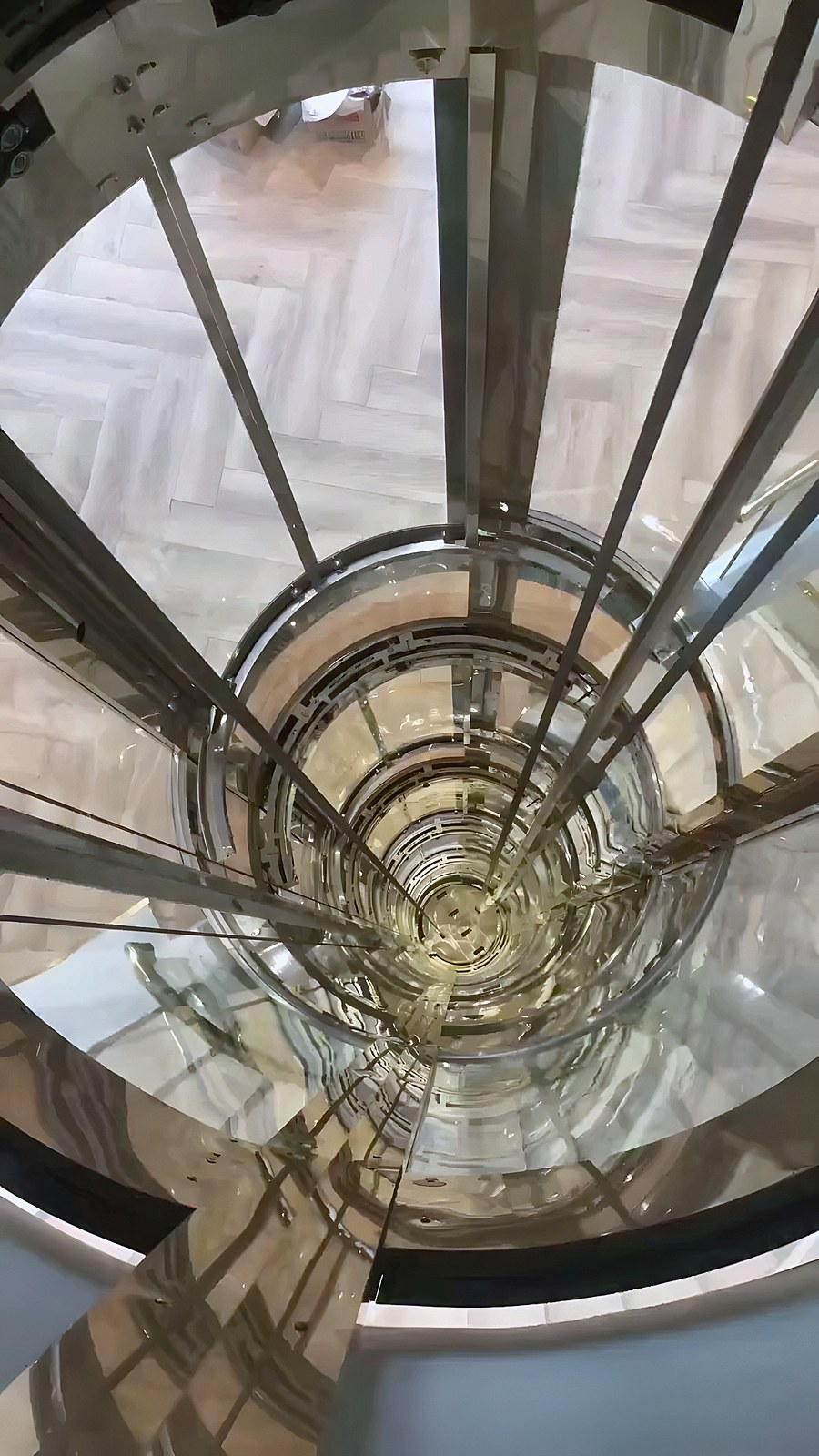 Glass lift inside a spiral staircase — from above