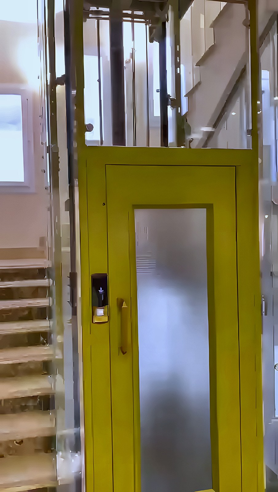 Landing door with a yellow frame for a panoramic lift